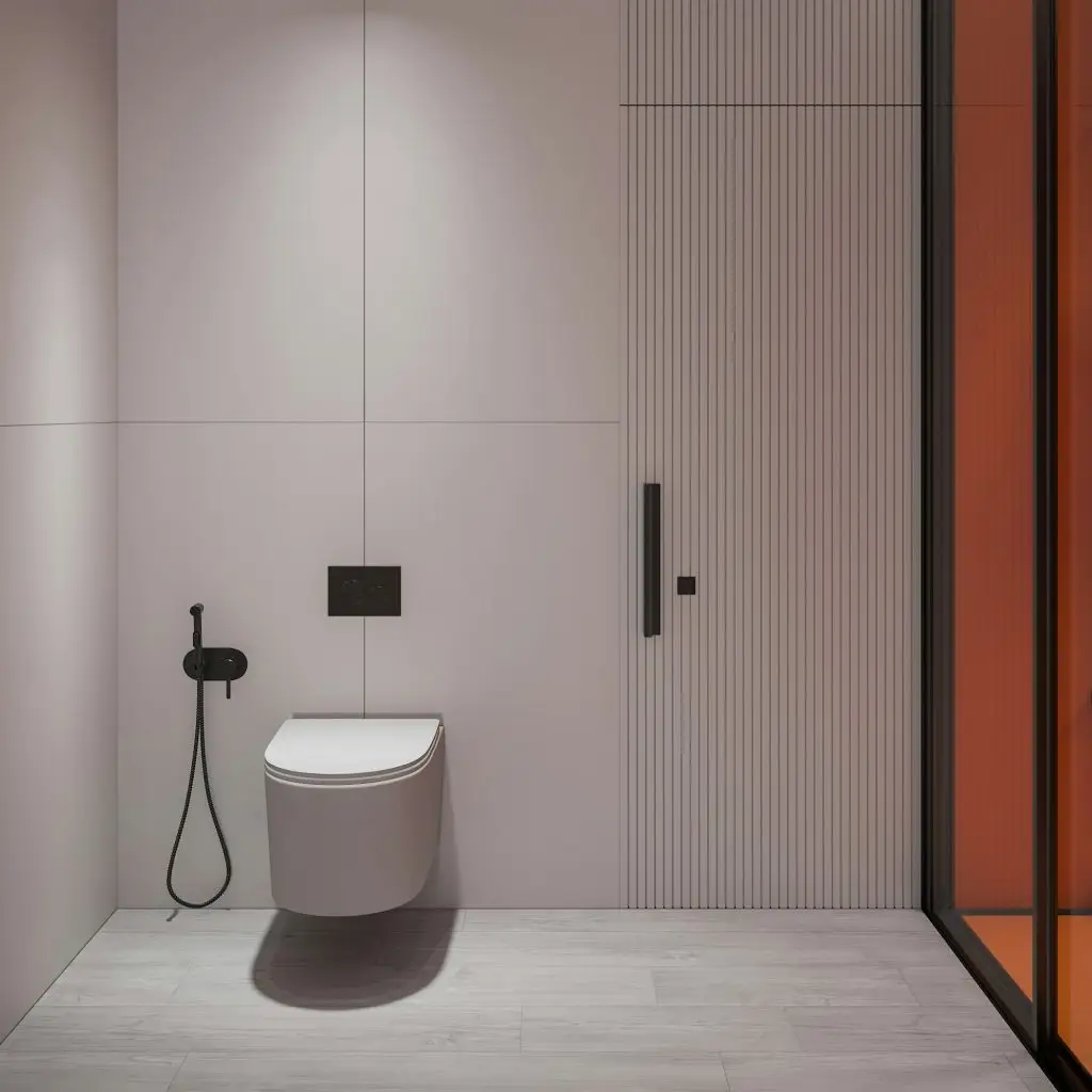 Salle de bain moderne avec toilette suspendue, robinet d’hygiène et douche vitrée contemporaine